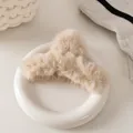 Dettaglio di una pinza per capelli in peluche beige su sfondo caldo ed estetico - Beige