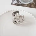 Close-up of a mini silver metal hair claw clip with a polished mirror finish on a ceramic plate - Large Eight-Claw - Silver