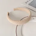 Nahaufnahme des beigen Strick-Stirnbands mit Köperwebung und internem Markenetikett - Milchtee