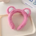 Detailed shot of pink plush bear ear headband for face washing and makeup styling - Light Pink