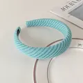 Detail of light blue knitted headband with textured diagonal weave and handmade label - Milk Blue