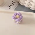 Détail d'une pince à cheveux fleur tricotée violette avec un centre jaune doux - Fleur Violette