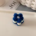 Vue détaillée de la pince à cheveux fleur tricotée bleue avec des détails centraux blancs - Fleur Bleu Klein