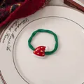 Detail eines Weihnachts-Haargummis mit rotem Hut-Charm und grünem Band auf einem weißen Teller - 2# Grünes Band - Weihnachtsmütze