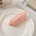 Close-up of pink glossy hair root clip on white plate for volume and styling - Pink