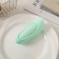 Macro shot of mint green hair root volume clip on white plate with journals - Green