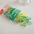 Macro detail of 100pcs colorful high-elastic candy color PU hair bands in clear packaging - Yellow-Green Series