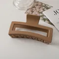Detail einer 13cm matt-karamell quadratischen Haarklammer für dickes Haar auf dem Tisch - Braun