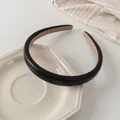 Detalle de diadema minimalista de cuero negro con forro interior de ante marrón suave - Negro