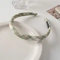 Detail of green plaid fabric headband with handmade tag on a white ceramic plate - Green Checkered