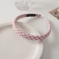 Close-up of pink gingham fabric headband with handmade tag on minimalist ceramic plate - Pink Plaid