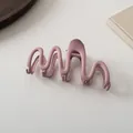 Detail view of wave-shaped mauve matte hair claw clip on minimalist textured background - Korean Pink