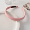 Detailed close-up of pink fabric headband featuring a black handmade textile label - Pink