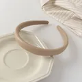 Primer plano de diadema de cuero caqui acolchada en un plato cerámico con forro antideslizante - Café con Leche