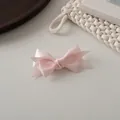 Detalle del pasador de lazo de satén rosa que muestra la textura suave de la tela y el corte de cola - Rosa Claro