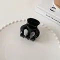 Detailed view of a glossy black hair claw clip on a minimalist white aesthetic background - Medium Octopus Style (10#)