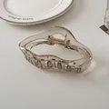 Detail of transparent gray hair claw clip with golden spring on a ceramic plate - Cloud Style (6#)