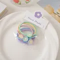 Close-up of four macaron-colored elastic hair ties with cute smiley face charms on a card - Smile Face Hair Tie