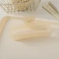 Détail d'une pince à cheveux carrée mate de couleur crème avec ressort métallique - Jelly Translucent White