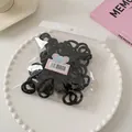 Detail of durable black mini hair ties in transparent packaging on a decorative tray - Basic Black Style / Black