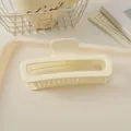 Vue détaillée d'une pince à cheveux carrée mate crème de 13 cm sur fond sobre - Blanc Mat