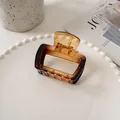 Detailed shot of amber gradient square hair claw clip on an elegant white tray - Tortoise