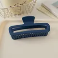 Détail d'une grande pince à cheveux rectangulaire bleu marine mat de 13cm sur un plateau - Bleu Marine Mat