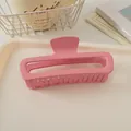 Détail macro d'une grande pince à cheveux carrée rose mat de 13 cm sur plateau - Rose Mat