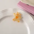 Detailed view of a cute resin bear hair clip with orange heart in a white dish - Jelly Yellow - Duckbill Clip