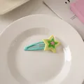Detail der Macaron-Stern-Haarspange mit bunten Sternen auf einem Keramikteller - Grün