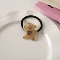 Detail of a black elastic hair tie with a brown translucent bear and hollow heart charm - Jelly Coffee - Hair Tie