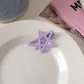 Detail of a purple hollow star hair clip with matte finish on a white ceramic plate - Light Purple Star