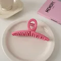 Detailansicht der glänzend rosa gewellten Haarklammer auf einem Keramikteller - Überkreuz-Stil / Himbeerrosa