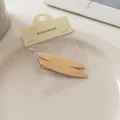 Detail von gebürsteten Gold-Haarspangen auf Keramikteller mit Zubehör-Kartonverpackung - Schlanker Ovaler Stil (7#)