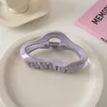 Glänzende lila Wellen-Haarklammer auf einem Keramikteller mit Lifestyle-Accessoires - Wolken-Stil / Helllila