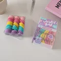 Detail of two boxes containing colorful elastic baby hair ties in macaron colors - Pink Purple