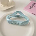 Detailaufnahme der hellblauen gewellten Haarklammer auf weißem Keramikteller - Wolken-Stil / Hellblau