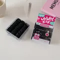 Close-up of black high-elastic hair ties in a transparent square baby size jewel box - Solid Black