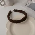 Close-up of a plush dark brown headband on a ceramic plate with lifestyle props - Dark Coffee
