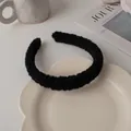 Gros plan détaillé d'un serre-tête en peluche noire en fausse fourrure sur un plateau décoré - Noir