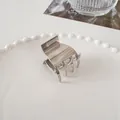 Mini silver metal claw clip for half-up hair styles on a white ceramic plate - Medium Square Claw - Silver