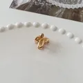 Mini golden butterfly hair claw clip with metallic hollow design on white ceramic tray - Mini Butterfly - Gold