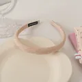 Detailed macro view of handmade light beige textured fabric headband with handmade label - Orange