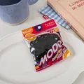 Detail of baby size black high elastic hair ties in clear packaging on a white plate - Solid Black