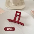 Makroaufnahme der 8cm tiefroten quadratischen Haarklammer auf weißem Dekoteller - Kleiner Stabstil