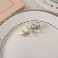 Dettaglio del fermaglio per capelli cuore perlato con strass e fiocco bianco nel piatto - 5# Beige Perla - Edizione Strass