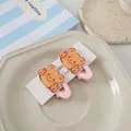 Detail von süßen gelben Cartoon-Bären-Haarspangen auf rosa Metall-Entenschnabelclips - Rosa