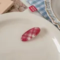 Detailed view of red plaid oval hair clip on a white plate with aesthetic background - Large Diagonal Plaid