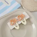 Nahaufnahme von zwei niedlichen cremegelben Bären-Haarspangen auf einem Keramiktablett - Beige