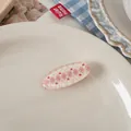 Close-up of oval resin hair clip featuring pink argyle pattern and red mini hearts - Argyle With Heart